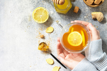 Woman holds a hot cup of ginger tea. Top view flat lay. Free space for your text.