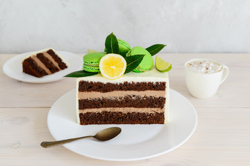 Sliced chocolate cake on a white wooden table.