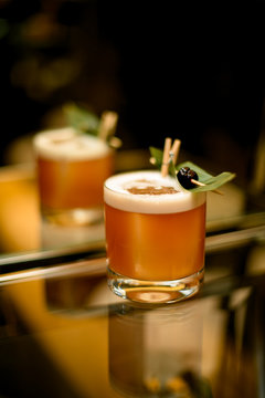 Creamy Color Cocktail Drink Decorated With A Green Tropical Leaf And Black Berry On The Toothpick