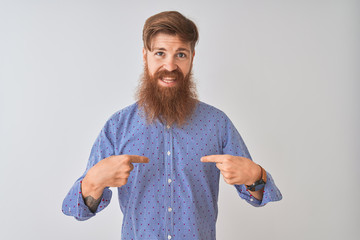 Young redhead irish man wearing casual shirt standing over isolated white background looking...