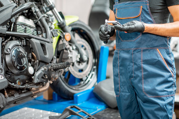 Mechanic repairing motorcycle at the workshop