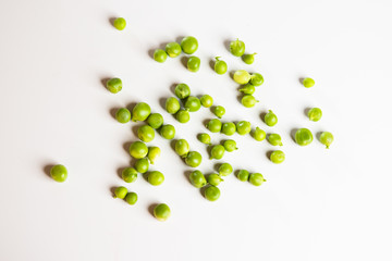 Green fresh scattered peas on a white background.