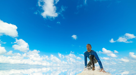 Surfer under a blue sky with clouds