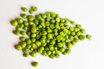 Green fresh scattered peas on a white background.