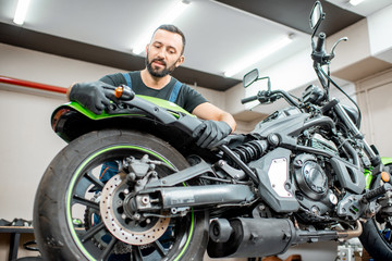 Worker repairing motorcycle in the workshop