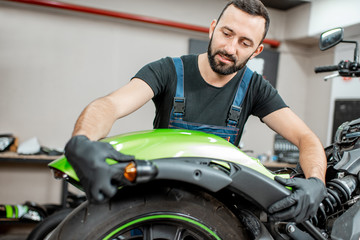 Fototapeta na wymiar Worker repairing motorcycle in the workshop