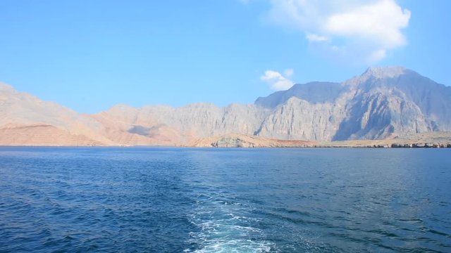 Blue waters of Musandam, Oman on a Dhow Boat trip in the Middle East the fjords, rocky mountains, and blue water near Strait of Hormuz 