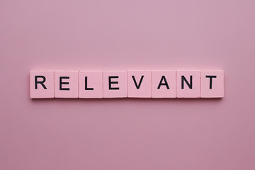 Relevant word wooden cubes on pink background