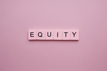 Equity word wooden cubes on pink background