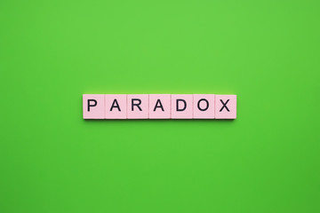 Paradox word wooden cubes on the green background.
