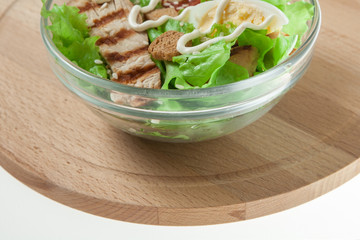 Caesar salad with grill chicken fillet isolated on white background