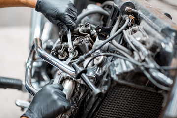 Obraz na płótnie Canvas Worker repairing motorcycle engine at the workshop