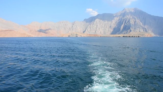 Blue waters of Musandam, Oman on a Dhow Boat trip in the Middle East the fjords, rocky mountains, and blue water near Strait of Hormuz 