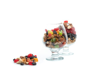 Two glasses with a variety of nuts and dried fruits. Colorful berries. A variety of nuts.