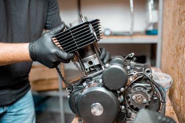 Fototapeta na wymiar Man repairing motorcycle engine