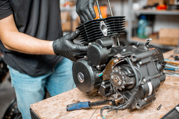 Man repairing motorcycle engine