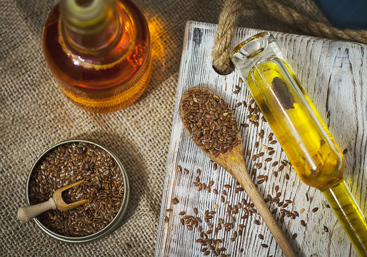 Flax seeds and linseed oil on wooden background