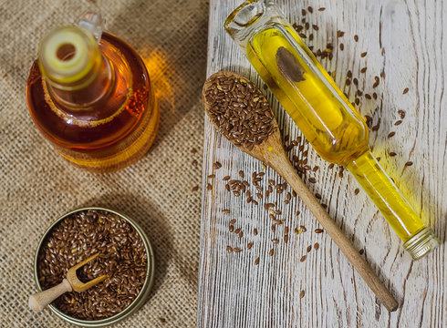 Flax seeds and linseed oil on wooden background