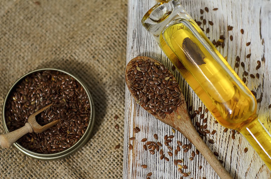 Flax seeds and linseed oil on wooden background