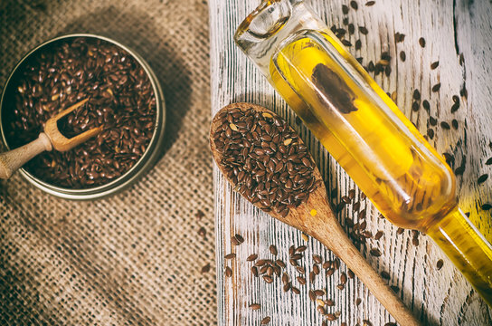 Flax seeds and linseed oil on wooden background