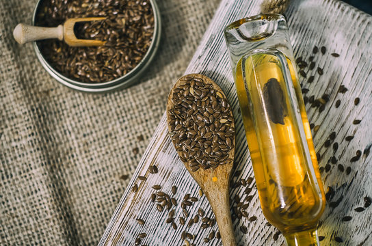 Flax seeds and linseed oil on wooden background