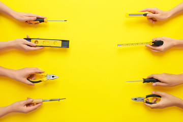 Female hands with set of electrician's supplies on color background