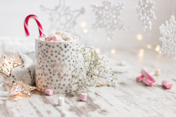 Fototapeta na wymiar christmas cup with marshmallow, handmade snowflakes, led stars on wooden backdrop