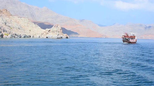 Blue waters of Musandam, Oman on a Dhow Boat trip in the Middle East the fjords, rocky mountains, and blue water near Strait of Hormuz 