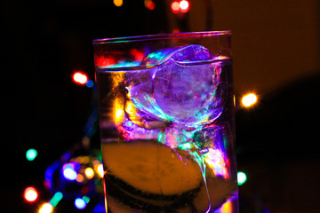 Gin tonic with cucumber: Close up of cocktail glass  with ice cubes in pink purple color. Colorful...