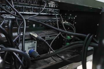 Music equipment closeup. Management console sound design at the event. Audio cable connected to the rear panel of high-quality audio equipment, an amplifier or mixer.