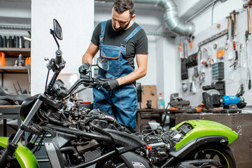 Fototapeta na wymiar Mechanic repairing or tuning motorcycle