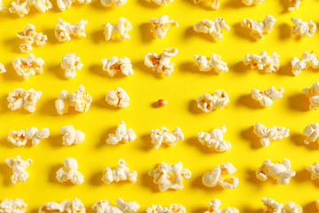 Many popcorn and one kernel on color background. Concept of uniqueness