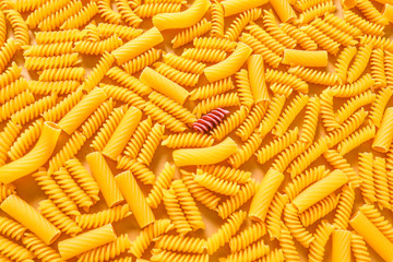 One pink pasta among others. Difference and uniqueness concept