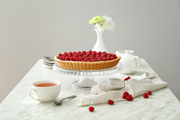 Tasty raspberry pie and tea set on table
