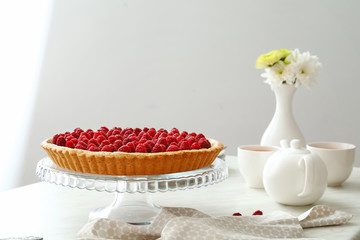 Tasty raspberry pie and tea set on table