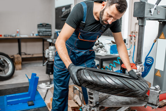 Worker Changing A Motorcycle Tire