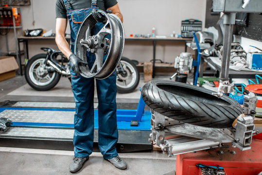 Worker Changing A Motorcycle Tire