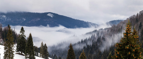 Beautiful rising fog in winter mountain landscape.