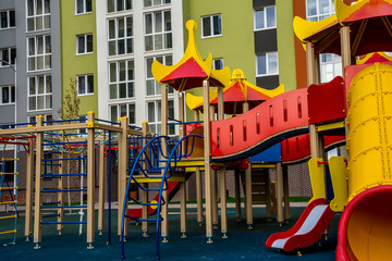 Children's complex of different swings in the courtyard of a multi-storey building. Bright and safe game that can be played by children.