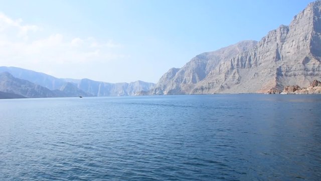 Blue waters of Musandam, Oman on a Dhow Boat trip in the Middle East the fjords, rocky mountains, and blue water near Strait of Hormuz 