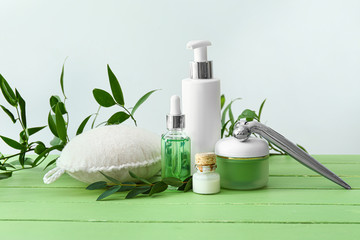 Cosmetics with bast wisp and massage tool on wooden table