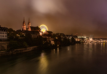 Obraz premium Dramatic night cityscape of the Basel old town skyline from the Rhine river, Switzerland.