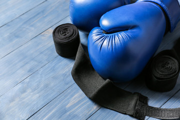 Boxing gloves and wrist bands on wooden background