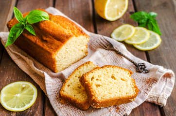 Lemon pound cake on rustic wooden background with lemon.