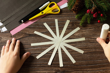 The child glues the gift symbol of 2020, a New Year's toy mouse made of Kraft paper. Handmade. The project of children's creativity, crafts, crafts for children.