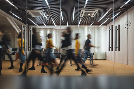 Group of business people walking at modern open space. Team of business employees at coworking center. Motion blur. Concept work in process