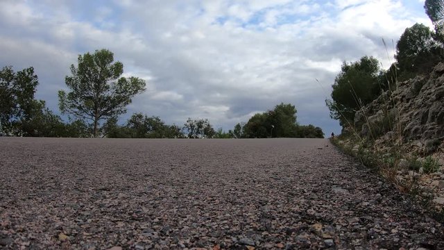 Motorbike in a rural road in third person with trees. (at floor level)(back)
