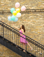 woman holding balloons on stairs 