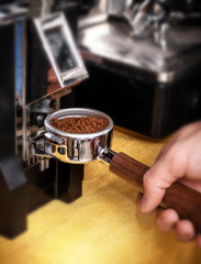 Macro shot grinding coffee on professional grinder machine