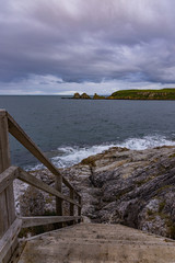Fototapeta na wymiar Wooden steps leading down to a rocky shoreline